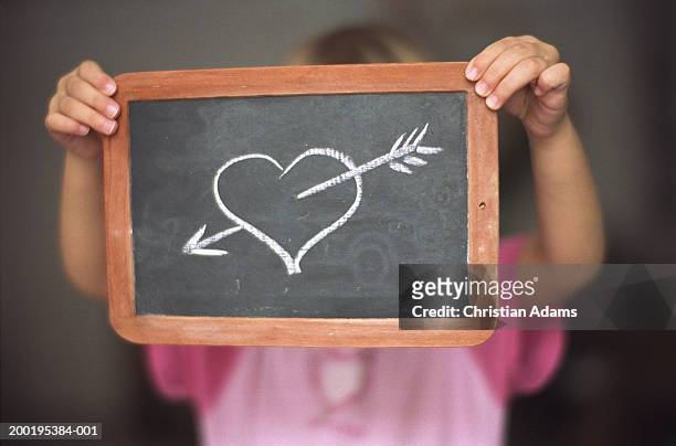 girl (2-4) holding chalk drawing of arrow through heart - chalk heart stock pictures, royalty-free photos & images