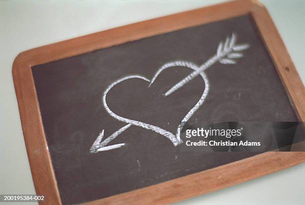 chalk drawing of heart through arrow - chalk heart stock pictures, royalty-free photos & images
