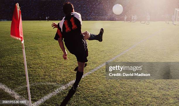soccer player making corner kick, rear view (digital enhancement) - corner kick - fotografias e filmes do acervo