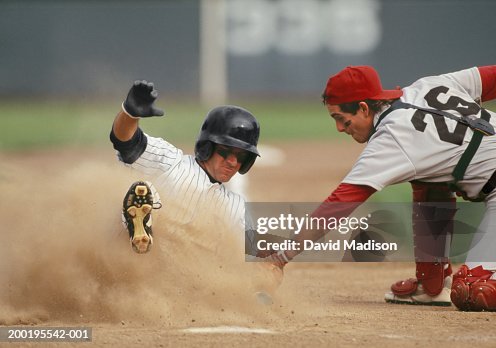 Baseball player sliding into home plate, being tagged by catcher Baseball player sliding into home plate, being tagged by catcher