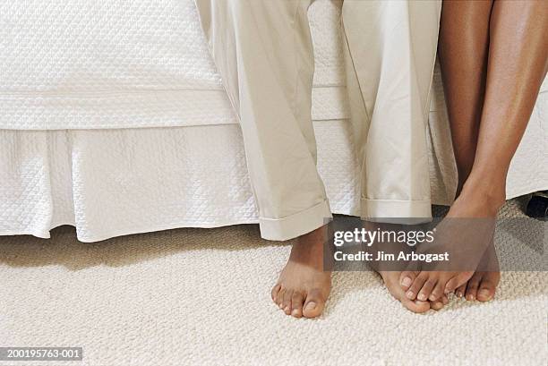 young couple sitting on side of bed, low section, close-up - girlfriend feet stock pictures, royalty-free photos & images