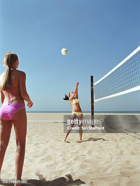 two young women playing volleyball on beach - girls beach volleyball stock pictures, royalty-free photos & images