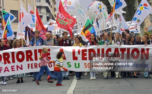 Des petites filles courent devant une banderole, le 17 octobre 2002 à Marseille, lors de la journée d'action de tous les personnels de l'Education...