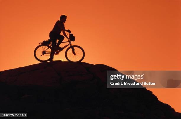 silhouette of man on mountain bicycle, side view, sunset - taking the plunge 個照片及圖片檔