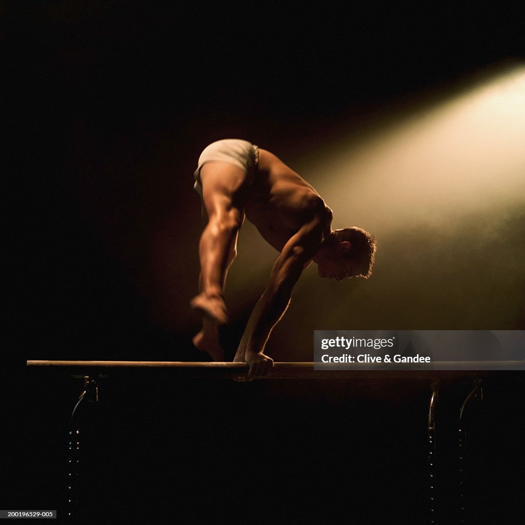 Male gymnast performing routine on parallel bars (blurred motion)