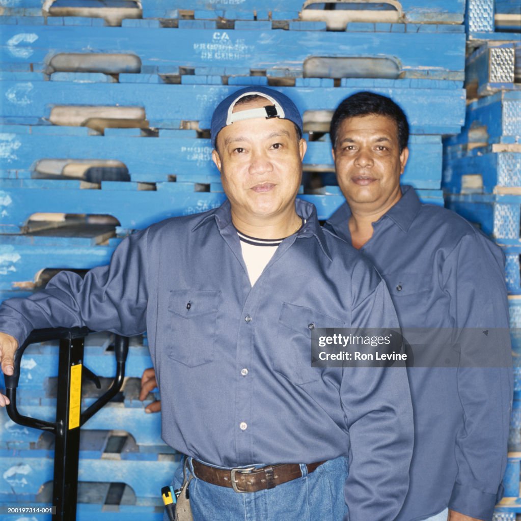 Two workmen in warehouse, portrait