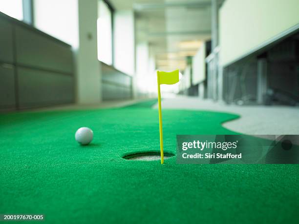miniature golf in office, focus on hole - minigolf stockfoto's en -beelden