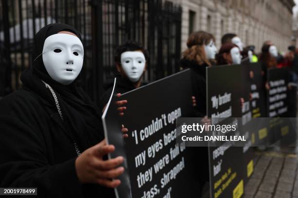 Activists from Amnesty International hold placards with statements made by civilians living in Rafah, in Gaza, during a silent vigil outside the...