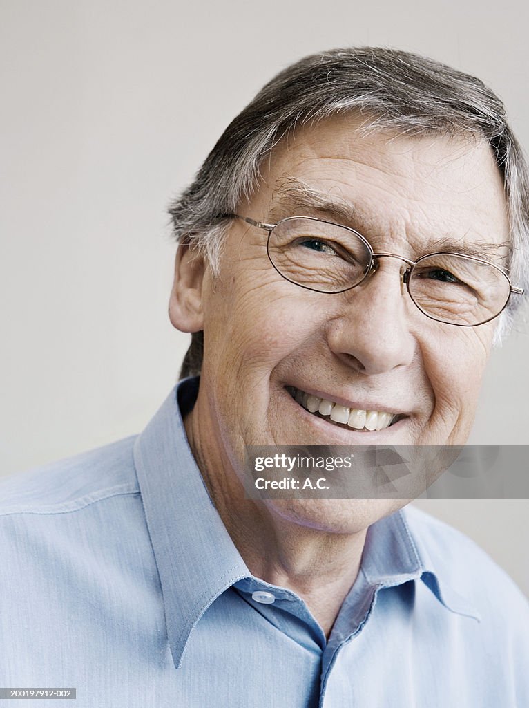 Senior man smiling, looking away, close-up