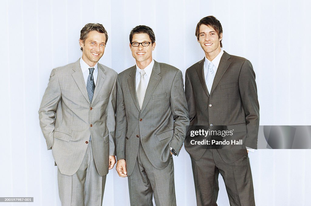 Three businessmen smiling, portrait