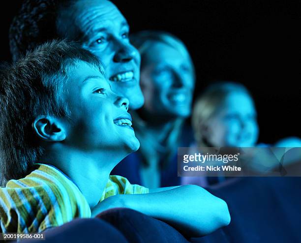 parents and children (8-10) in cinema, smiling (focus on boy) - cinema audience imagens e fotografias de stock