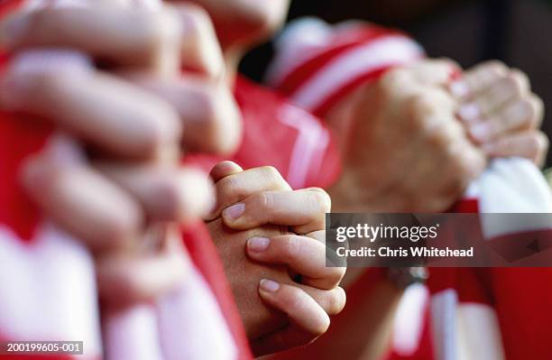 supporters at football match, close-up of clutched hands - cu fan stockfoto's en -beelden