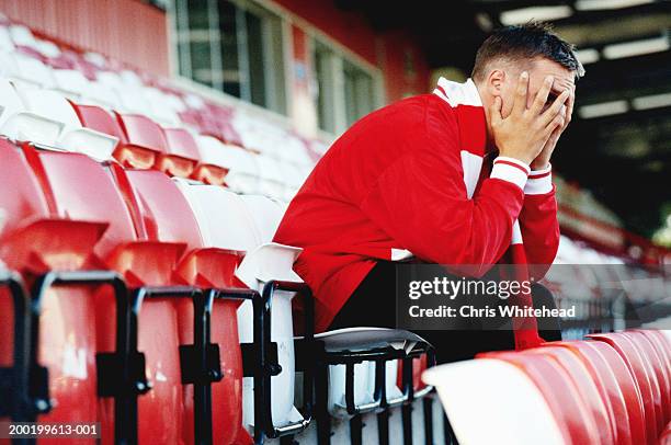 supporter sitting in empty football stadium, head in hands - fan schal stock-fotos und bilder