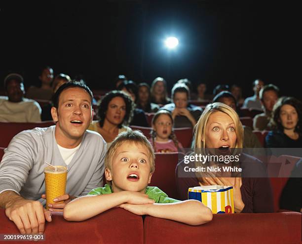 parents and son (9-11) in cinema reacting to film, close-up - kinosaal stock-fotos und bilder