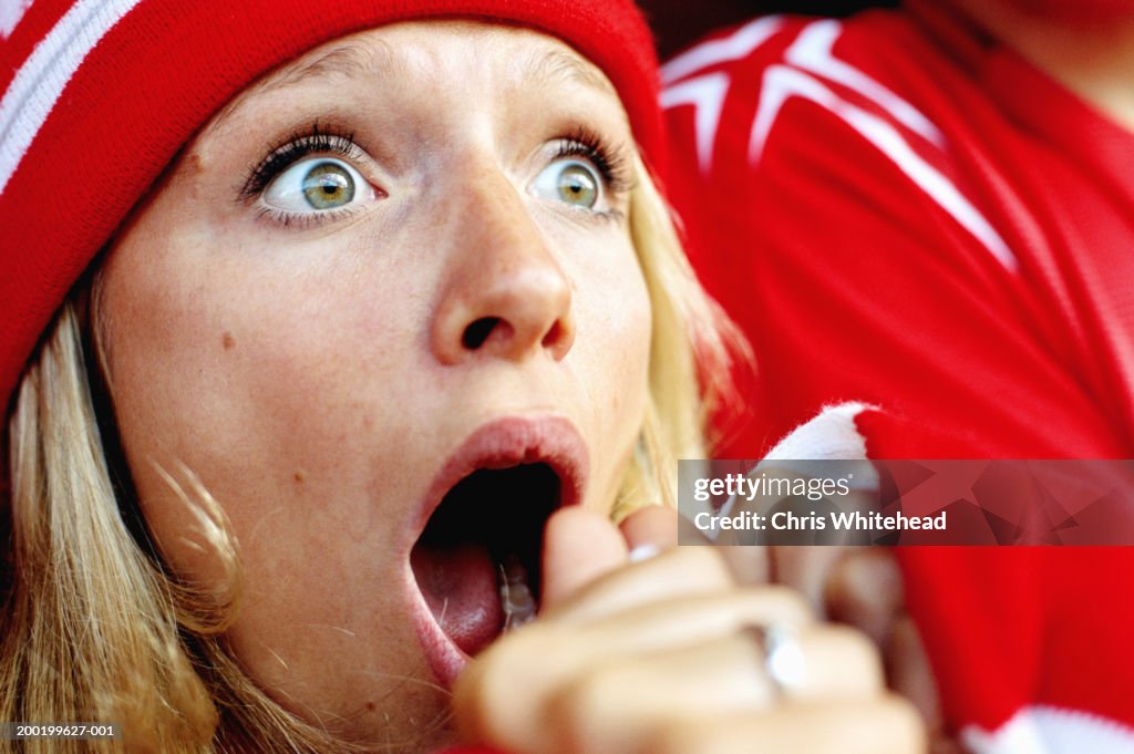Female football supporter at match, gasping, close-up