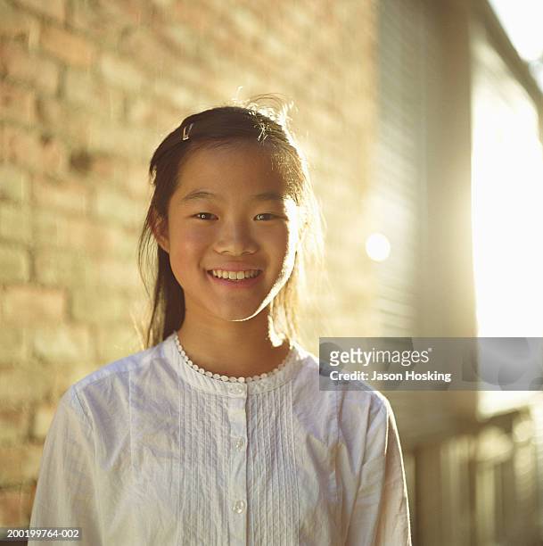 teenage girl (12-14) standing outside house, portrait - asian girl smile stock pictures, royalty-free photos & images
