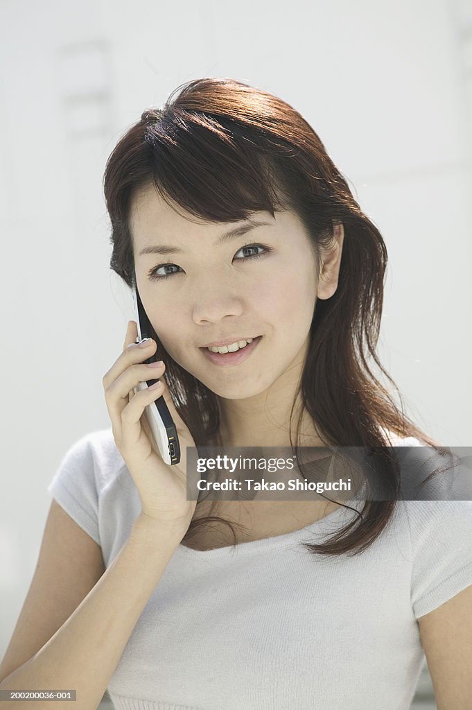 Young woman talking on mobile phone, portrait, close-up