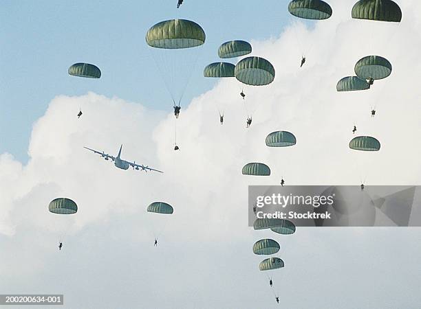 soldiers parachuting after training jump from lockheed c-130 hercules - paracaídas fotografías e imágenes de stock