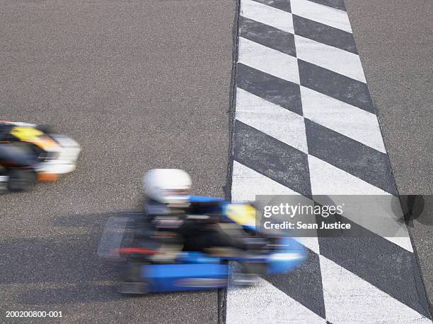 go-cart racer crossing finish line, elevated view (blurred motion) - corrida de cart - fotografias e filmes do acervo