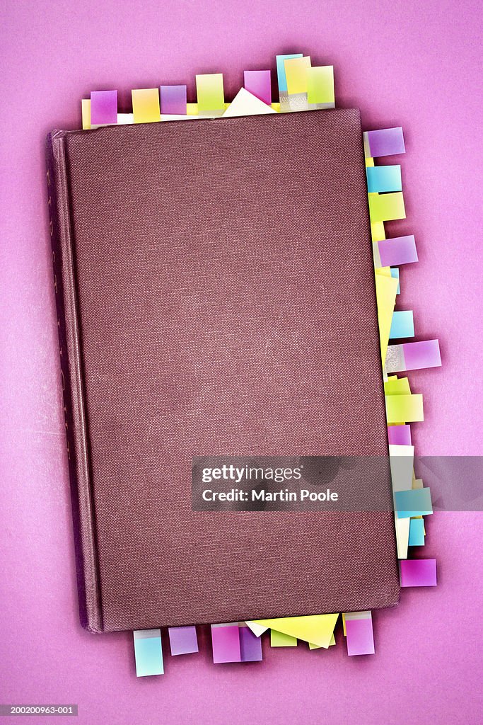 Notebook with sticky notes marking pages, overhead view