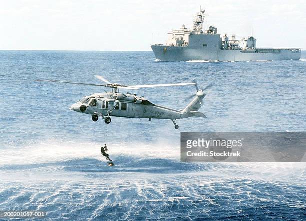 sikorsky mh-60s knighthawk retrieving soldier from atlantic ocean - helicopter stock-fotos und bilder
