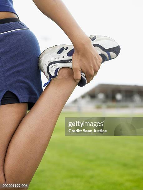 teenage girl (14-16) stretching leg, low section, close-up - leg stretch girl stock pictures, royalty-free photos & images