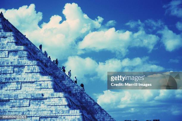 tourists climbing el castillo temple in mayan ruins of chichen itza - kukulkan pyramid stock pictures, royalty-free photos & images