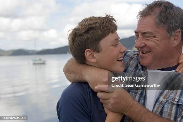 father and son (12-14) embracing, outdoors, close-up - prender a cabeça imagens e fotografias de stock