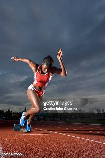 female sprinter leaving starting blocks - running shorts foto e immagini stock