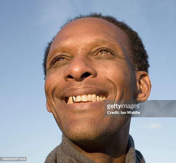 mature man outdoors, smiling, low angle view - capped tooth stock-fotos und bilder