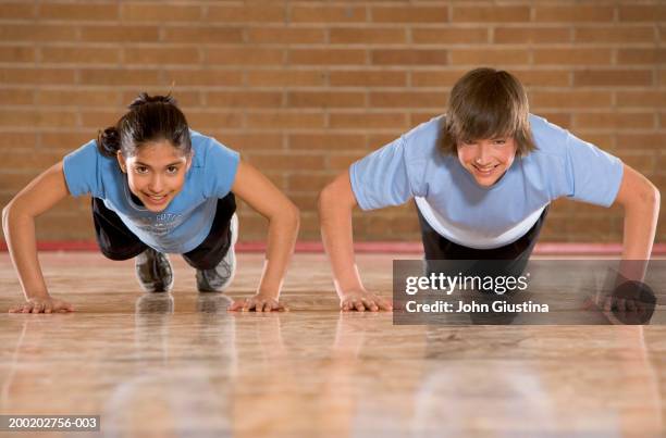 schoolchildren (11-15) in gym doing push ups - john hale stock pictures, royalty-free photos & images