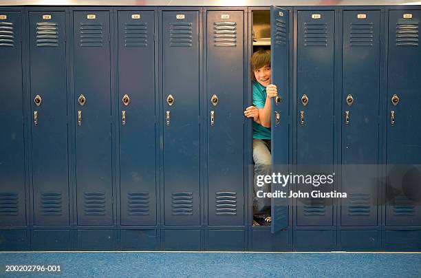 teenage boy (13-15) coming out of locker - school appearance stock pictures, royalty-free photos & images