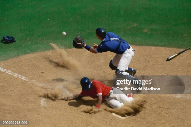 baseball catcher fielding ball as base runner slides into home - baseball sport stock pictures, royalty-free photos & images