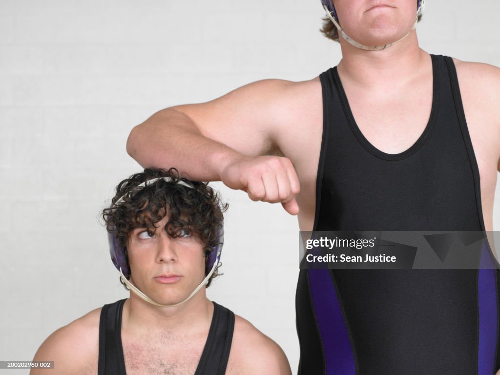 Teenage boys (16-18) wrestler, leaning on short boy
