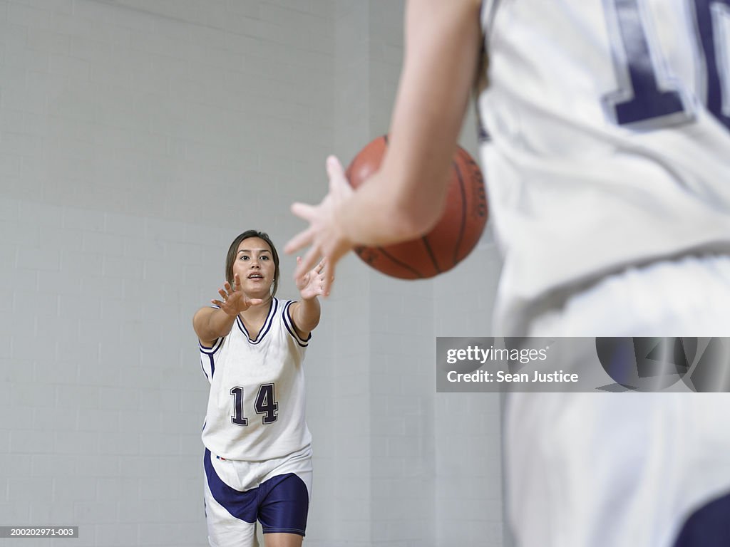 Teenage girls (14-16) basketball players, passing ball