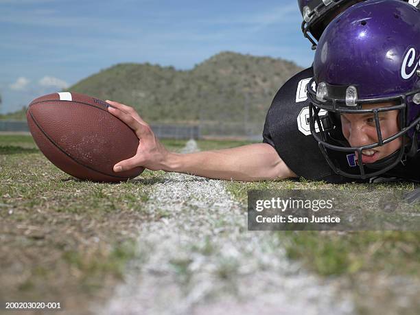 teenage boy (16-18) football player on field, touching ball - day 16 stock-fotos und bilder