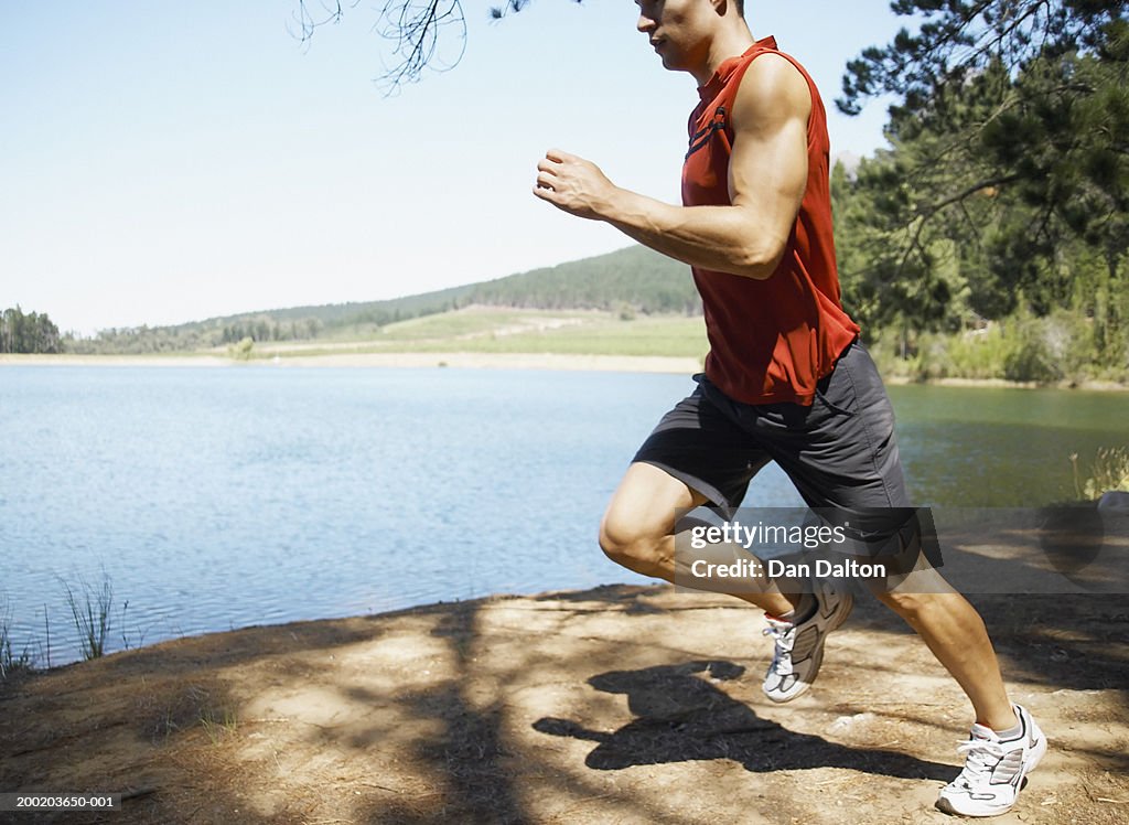 Young man running by lake