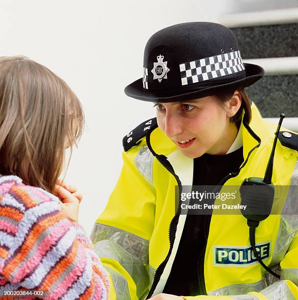 policewoman crouching to talk to girl (3-5), close-up - mulher polícia imagens e fotografias de stock