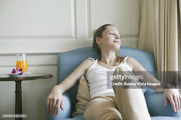 young woman relaxing on chair, looking away - 2005 20 stock pictures, royalty-free photos & images