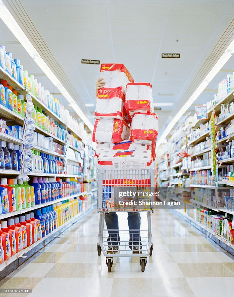 Man with cart stacked with grocery