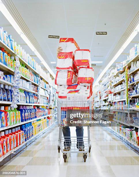 man with cart stacked with grocery - buying toilet paper photos et images de collection