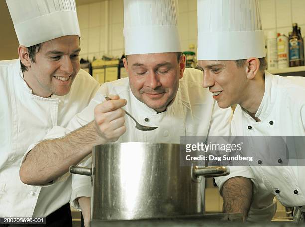 three chefs looking over saucepan, close-up - dag 3 imagens e fotografias de stock