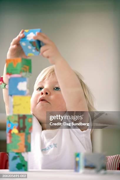 baby girl (15-18 months) playing with building blocks, close-up - one baby girl only - fotografias e filmes do acervo