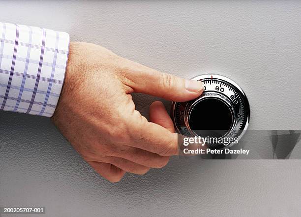 man turning safe dial, close-up - safe lock stock pictures, royalty-free photos & images