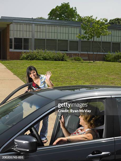 teenage girl (13-15) getting out of mother's car in front of school - open day 13 stock pictures, royalty-free photos & images