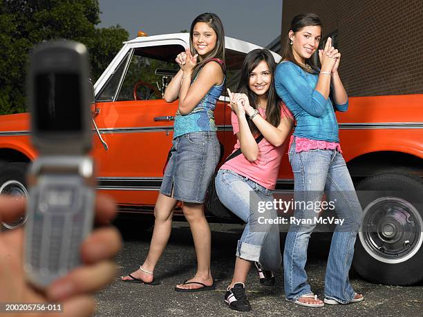 person photographing three teenage girls (14-16) beside pick-up truck - 映画調 ストックフォトと画像