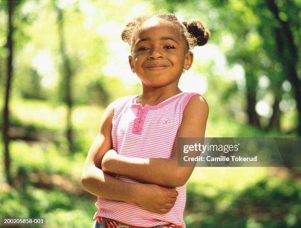 girl (4-6) with arms folded in park, smiling, portrait - kids proud stock pictures, royalty-free photos & images