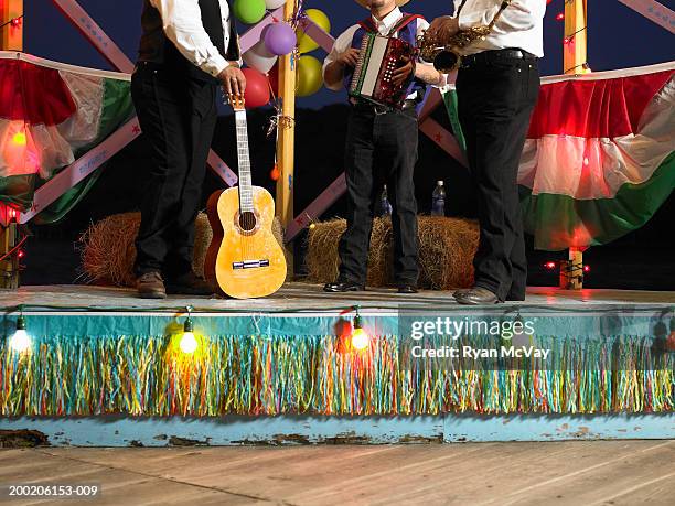 drei männer auf der bühne mit gitarre, akkordeon und saxophon - accordion instrument stock-fotos und bilder