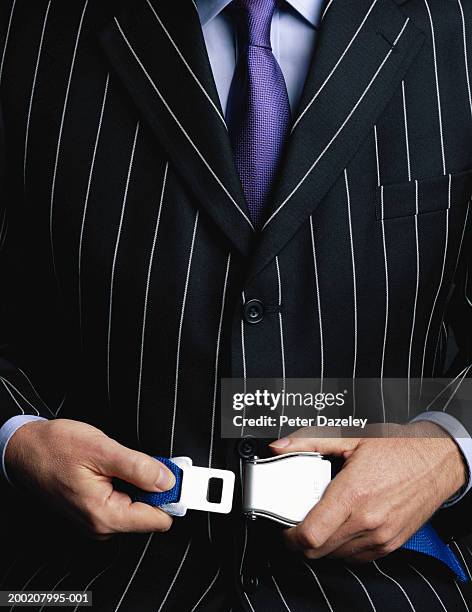 businessman fastening seatbelt, close-up - striped suit stock-fotos und bilder