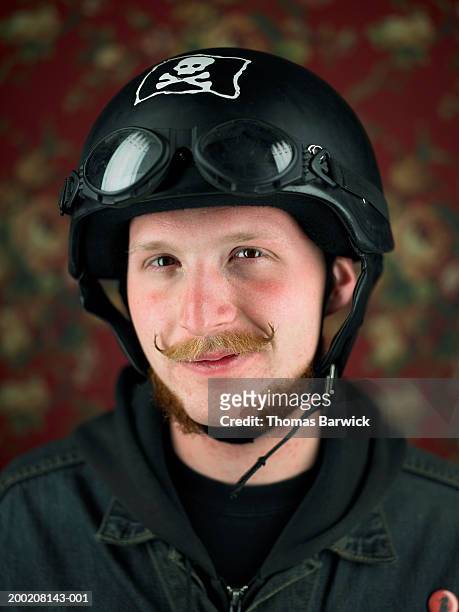 young man wearing motorcycle helmet, smiling, portrait - skull helmet stock pictures, royalty-free photos & images